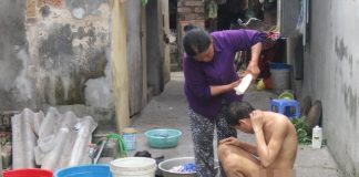 Hàng ngày, bà Thuân phải tự tay tắm rửa, vệ sinh cho các con. Ảnh: M.L