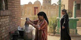Một phụ nữ sống trong khu nghĩa trang Cairo đang làm sạch các ngôi mộ.