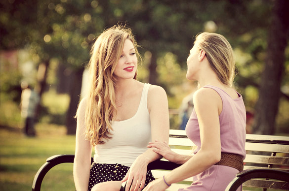 good friends having a heart to heart talk out on a park bench